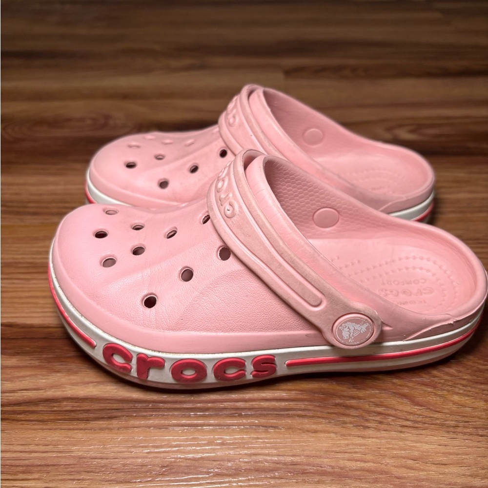 Kids adorable pink Crocs clogs featuring the iconic logo
